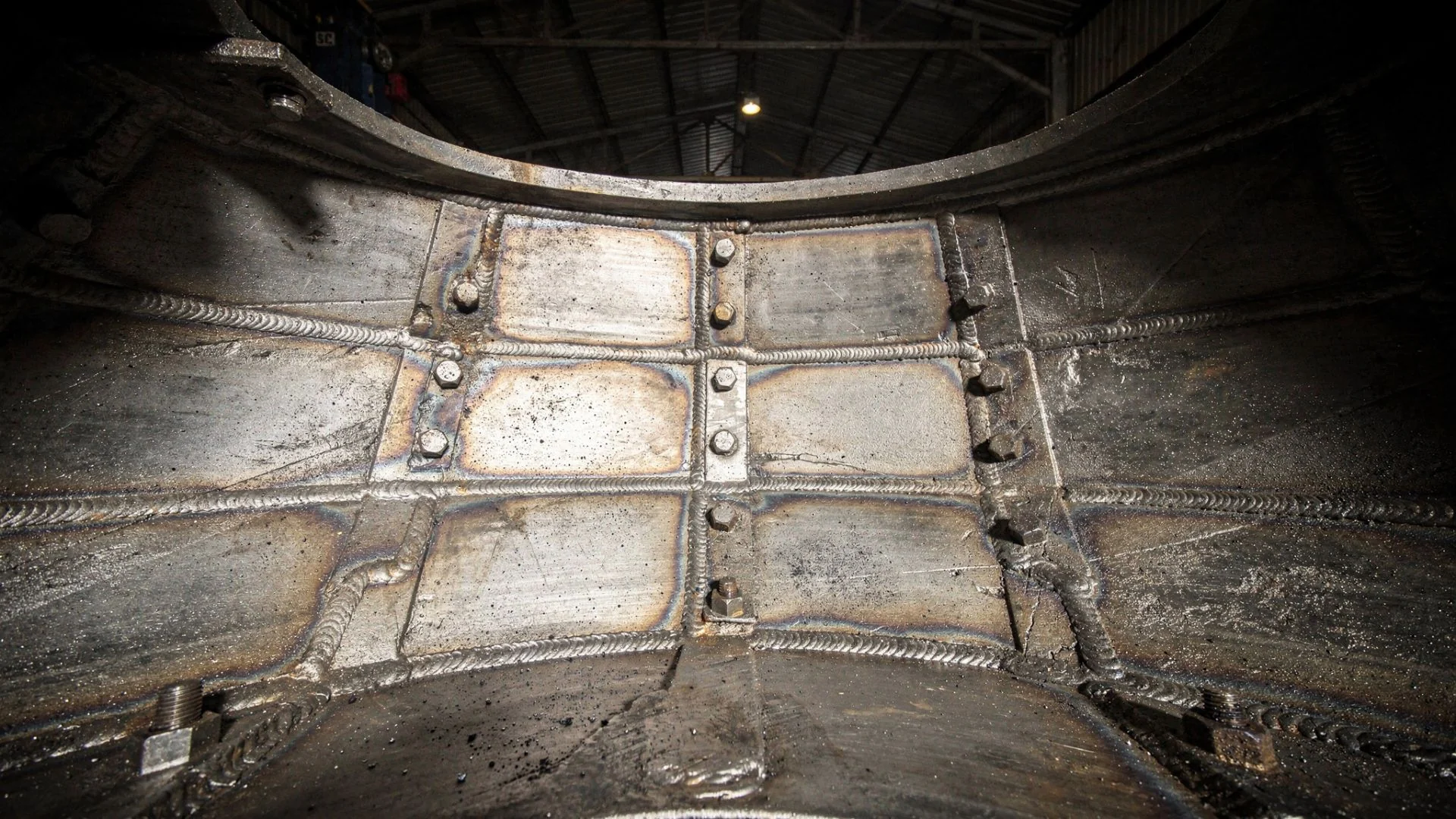 Interior de moinho industrial com placas de revestimento duro soldadas e cordões antidesgaste aplicados pela CRM Caldeiraria